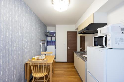 a kitchen with a table and a white refrigerator at 今和Hotel in Tokyo