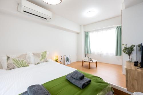 a bedroom with a large bed with a green blanket at 今和Hotel in Tokyo