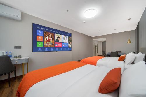 a hotel room with two beds and a large screen at Guangzhou Yashay International Apartment - Pazhou Convention and Exhibition Centre in Guangzhou