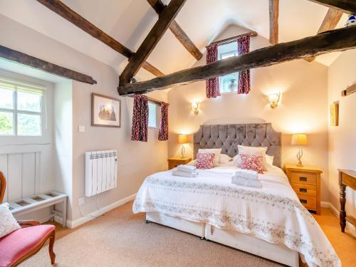 a bedroom with a large bed and windows at Foxglove - W43183 in Hawnby