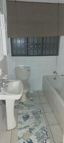 a bathroom with a toilet and a sink and a tub at Juanita 105 - 8 Sleeper in Margate