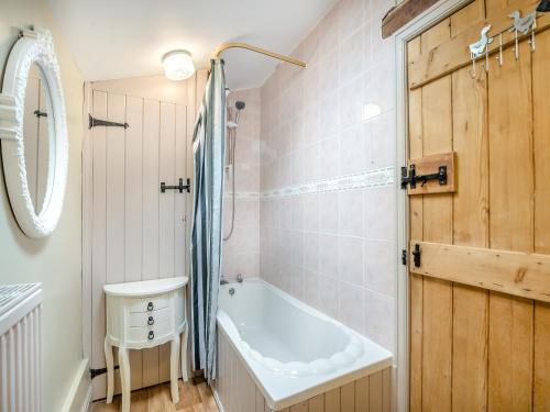 ein Badezimmer mit einer Badewanne und einem Waschbecken in der Unterkunft Bridge Cottage - W43184 in Hawnby