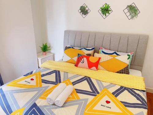 ein Schlafzimmer mit einem Bett mit bunten Kissen in der Unterkunft AFINITI-Legoland-walk5min CottonSheep 2RB Max8pax Bathtub in Nusajaya