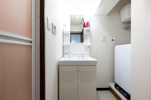 a small bathroom with a sink and a refrigerator at 今和Hotel in Tokyo