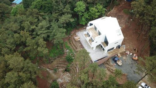 an aerial view of a white house in the woods at Forestel Meomul in Suncheon