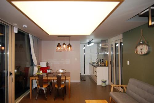a living room with a dining room table and a kitchen at Forestel Meomul in Suncheon