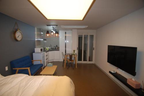 a bedroom with a bed and a living room with a television at Forestel Meomul in Suncheon
