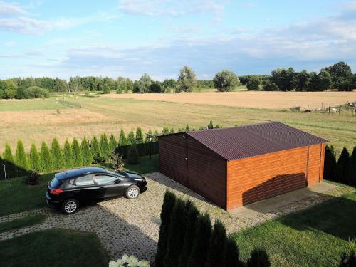 a car parked in front of a small wooden building at Apartment in Stepnica near Szczecin Lagoon in Stepnica