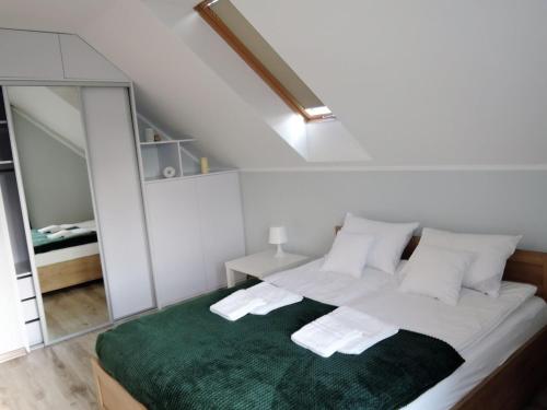 ein Schlafzimmer mit einem großen Bett und einer grünen Decke in der Unterkunft Apartment with a swimming pool in Stepniczka in Stepnica