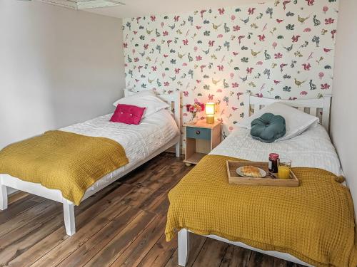 a bedroom with two beds and a tray of food on a tray at Pixies Wood Cottage in Ludham