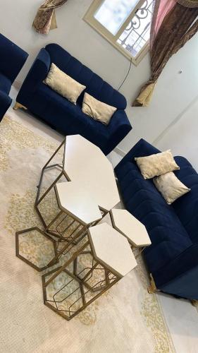 ein Wohnzimmer mit einem Sofa, einem Tisch und Stühlen in der Unterkunft شقه فاخره بغرفة نوم وغرفة جلوس in Sūq al Aḩad
