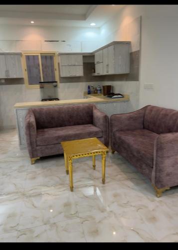 a living room with two couches and a coffee table at شقه فاخره بغرفة نوم وغرفة جلوس in Sūq al Aḩad