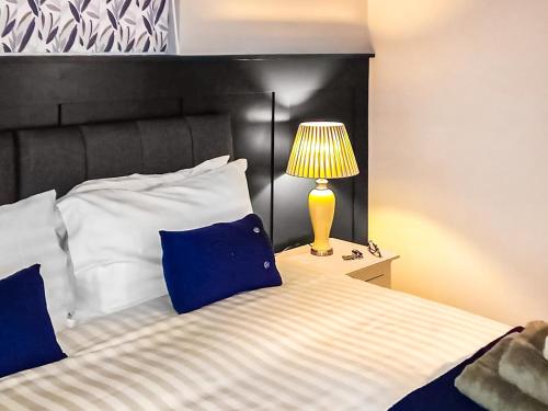 1 dormitorio con 1 cama con lámpara en una mesita de noche en Cuckoo Lodge - Uk42541 en Winforton