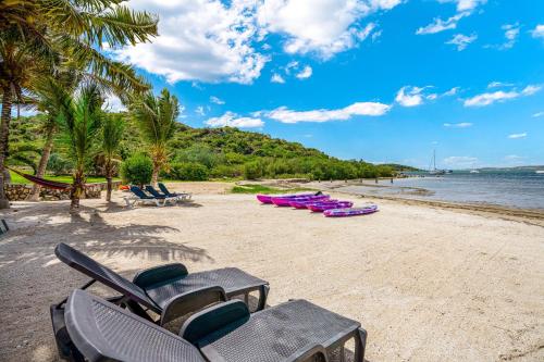 a beach with chaise lounges and chairs on it at Studio Stmartin in Cul de Sac