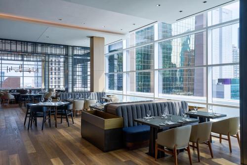 a restaurant with tables and chairs and large windows at JW Marriott Dallas Arts District in Dallas