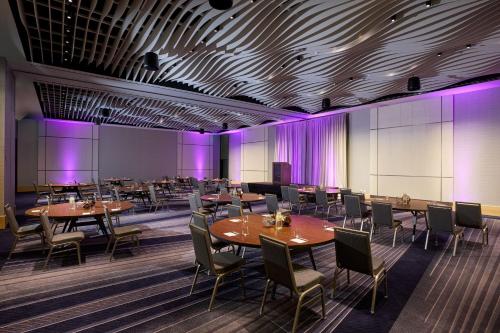 a dining room with tables and chairs and purple lighting at JW Marriott Dallas Arts District in Dallas