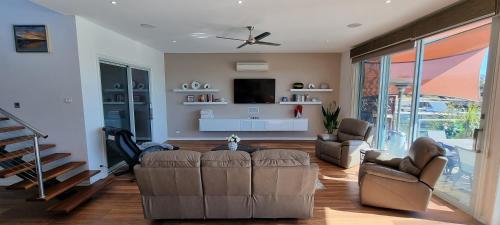a living room with a couch and a tv at Clearview Waters - 4 King bedrooms, 3 bathrooms & views in Mildura