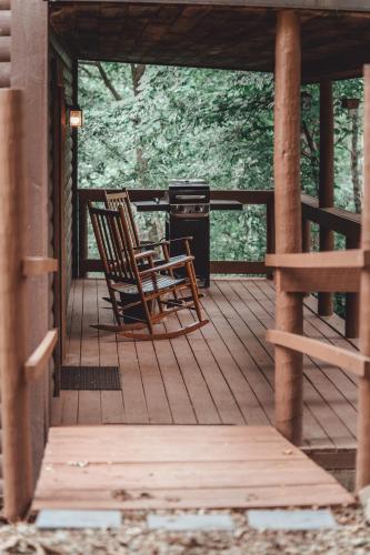two chairs sitting on a porch with a grill at Great Frontier Cabin at American Heartland Cabins in Rockbridge