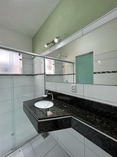 a bathroom with a sink and a mirror at Pousada Paraty Graziela in Paraty