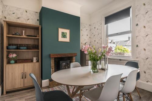 comedor con mesa, sillas y chimenea en Picton House: Charming 3 bed property in quiet location, en Ramsgate