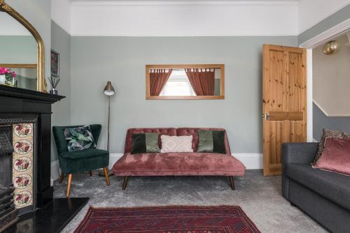sala de estar con sofá rojo y 2 sillas en Picton House: Charming 3 bed property in quiet location, en Ramsgate