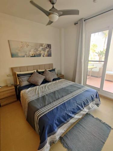 1 dormitorio con 1 cama grande y ventilador de techo en Casa Ana, en Murcia