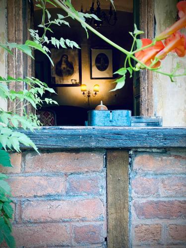 une fenêtre sur un mur en briques avec une bougie dans l'établissement COLONIALE, à Cîmpulung
