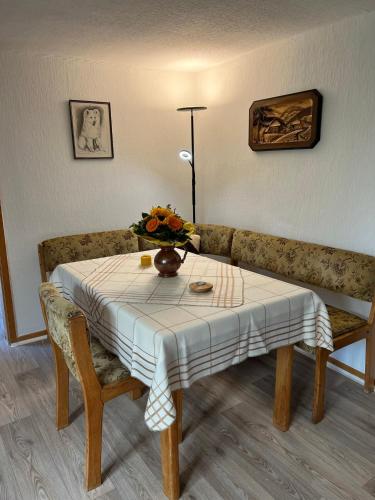 a table with a vase of flowers and a couch at Gemütliche Wohnung im Herzen vom Dorf in Mudersbach