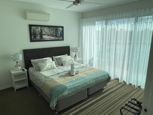 - une chambre avec un lit et une grande fenêtre dans l'établissement Clearview Waters - 4 King bedrooms, 3 bathrooms & views, à Mildura