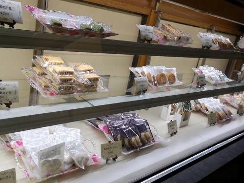 a shelf filled with different types of cakes and pastries at Yamano Hidaya in Matsumoto
