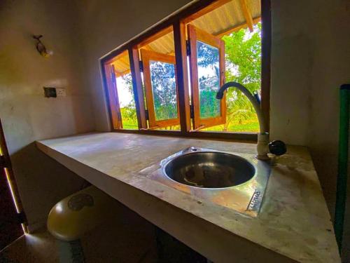 encimera de cocina con fregadero y ventana en Nelumgala Cottage -Village Experience, en Galewela