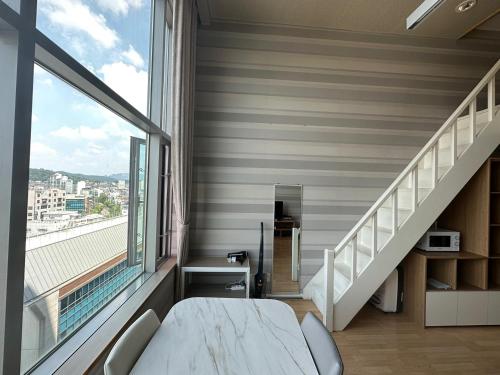 um quarto com uma cama e uma grande janela em Hongdae Guesthouse2 1min from Hongik Uni station Exit #1 em Seul