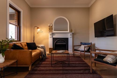 a living room with a couch and a fireplace at Highgrove Cottage in Eurunderee