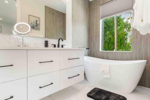 a bathroom with a tub and a sink and a mirror at Luxury Paradise walk to Las Olas -5 mins to Beach in Fort Lauderdale