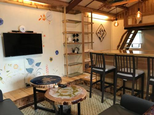 a living room with a bar and chairs and a television at A-HOME in Jiufen