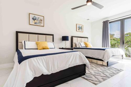 a bedroom with two beds and a ceiling fan at Luxury Paradise walk to Las Olas -5 mins to Beach in Fort Lauderdale