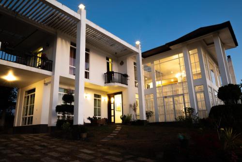 Une grande maison blanche éclairée dans l'établissement The Grove, à Kandy