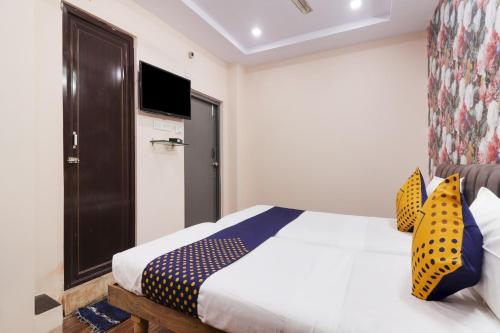 um quarto com uma cama com almofadas amarelas e azuis em OYO Hotel 74966 Shree Amardeep Hotel em Hyderabad