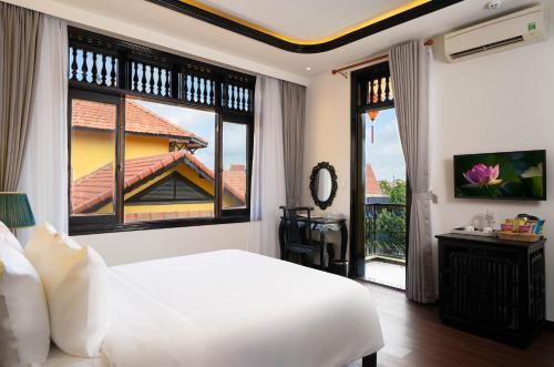 a bedroom with a white bed and a large window at Oriental Boutique Hoi An in Hoi An