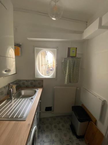 une petite cuisine avec un évier et une fenêtre dans l'établissement Coeur de Versailles Notre Dame - 3 pièces, à Versailles