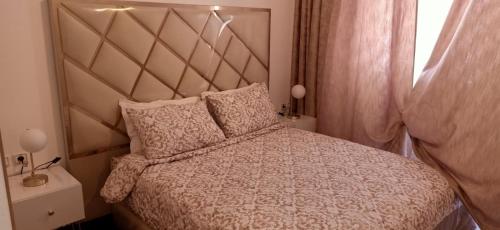 a bedroom with a bed with a large headboard at Appartemnt Essaouira welcome all in Essaouira