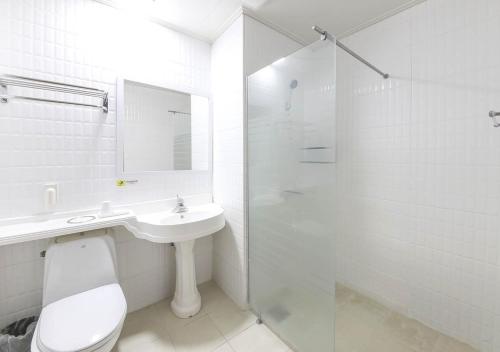 済州市にあるチェジュ パークサイド ツーリスト ホテルのバスルーム(トイレ、洗面台、シャワー付)