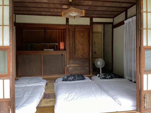 a room with three beds and a fan at ペット可 Akiu-Canada 鴻ノ巣温泉 in Sendai