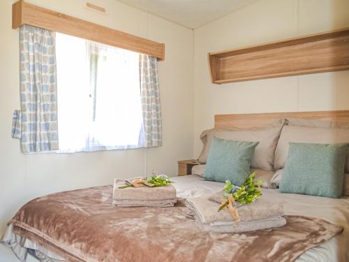 Hillcrest Caravan - Uk44798 في Hemswell: غرفة نوم عليها سرير وفوط