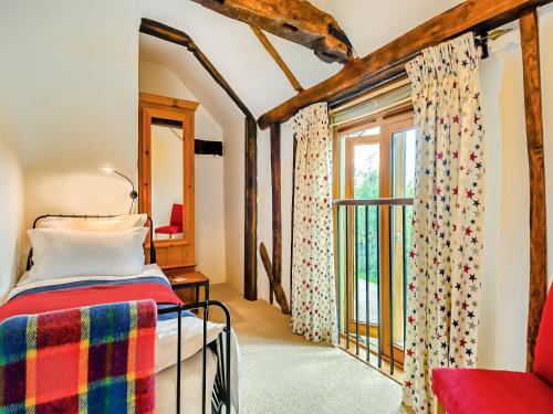 um quarto com uma cama e uma janela em The Cottage Barn em Botesdale