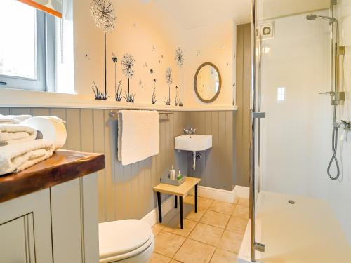a bathroom with a shower and a toilet and a sink at The Cottage Barn in Botesdale