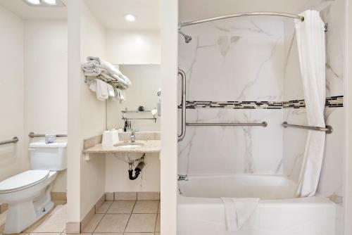 y baño con ducha y aseo. en DOWNTOWN SLO INN - SAN LUIS OBISPO en San Luis Obispo