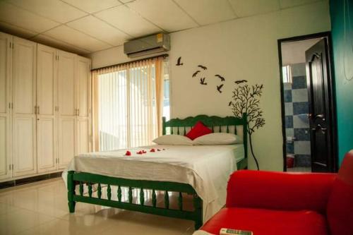 a bedroom with a bed and a red couch at Hostal Casa del Sol in Santa Marta