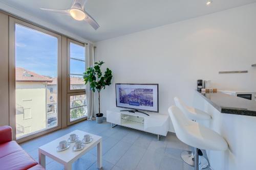 a living room with a couch and a tv at Residenza Castello - Happy Rentals in Mendrisio