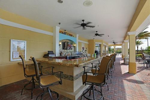 a bar in a restaurant with chairs around it at Vista Cay Resort by Millenium at Universal Blvd. in Orlando